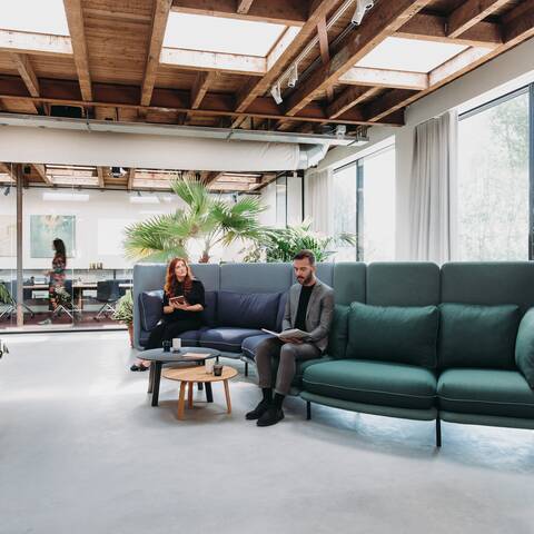 Embrace Royal Ahrend Embrace sofa upholstered in green and blue with female and male model at HofmanDurjandin office in Diemen EB005