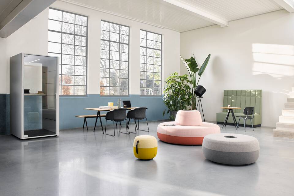 Qabin, Pyramid, Well Armchair, Recharge 45, Recharge 100, Recharge 165, Revolt, Engage Ahrend Recharge poufs upholstered in pink yellow and grey with Qabin and Pyramid with Well armchairs in a Hybrid working community setting