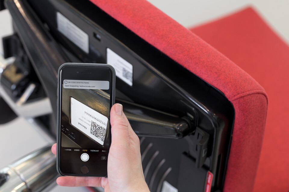 Asset Management Royal Ahrend service Asset Management female model holding phone scanning office chair QR code under seat bottom view