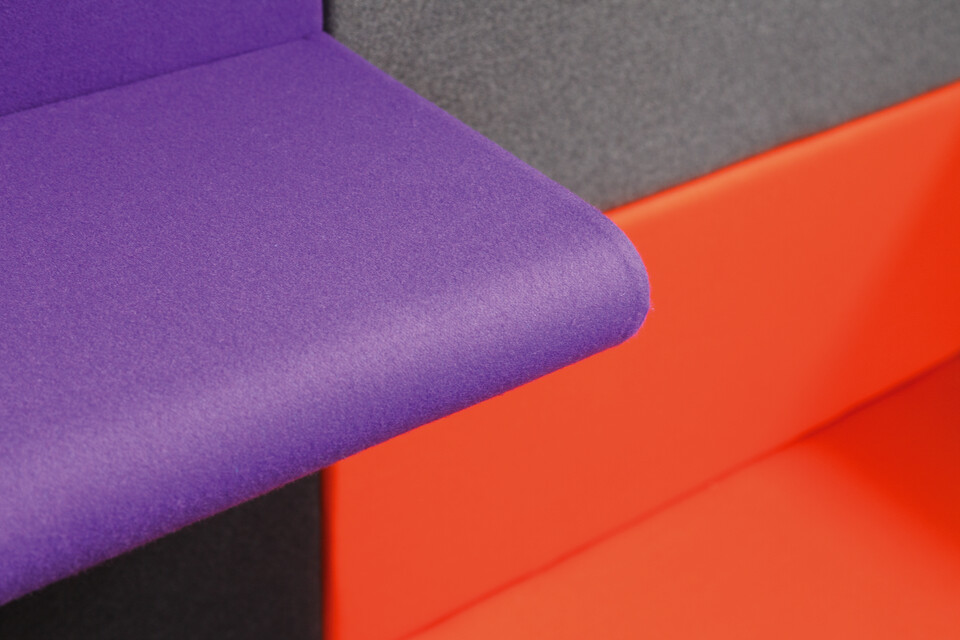 Living Wall Royal Ahrend Living Wall panels upholstered in grey with purple armrest panel and orange seating panel front left view