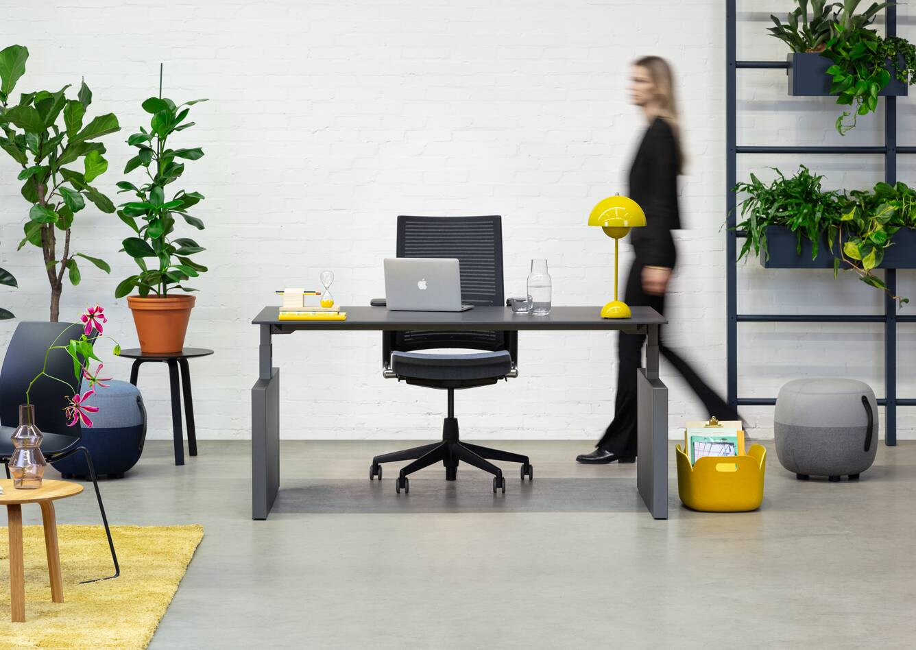 Balance Lift, Well, Recharge 45, 2020 Extra Verta Royal Ahrend Balance Lift workstation in grey with charcoal top and 2020 office chair with female model walking front view