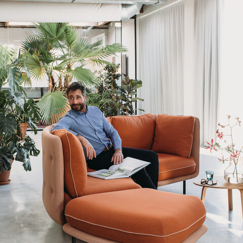 Embrace Royal Ahrend Embrace sofa upholstered in red and yellow with male model at HofmanDurjandin office in Diemen EB017