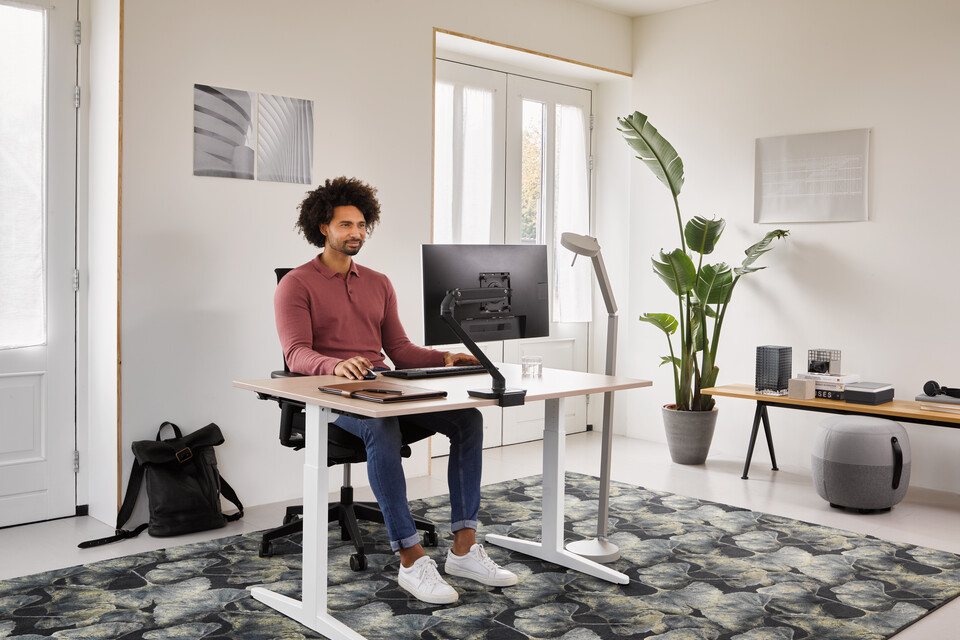 Home, Ease, Pyramid Bench 12, Recharge 45 Ahrend Home HVM desk in white with oak tabletop and black Ease office chair with grey Recharge and Pyramid bench with male model thinking in a work from home setting