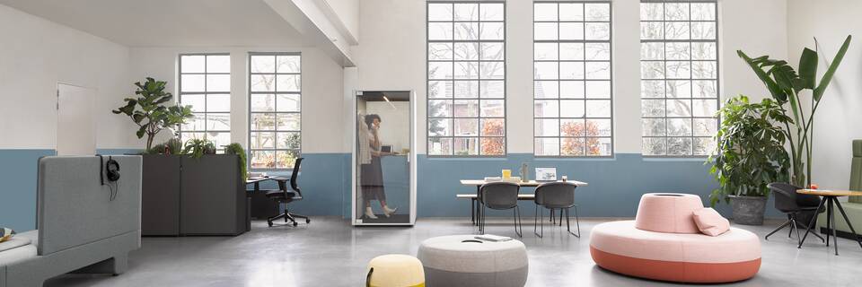Loungescape Powernap, Sliding Door Cabinet, Balance, Ease, Qabin Call, Pyramid, Well Armchair, Recharge 45, Recharge 100, Recharge 165, Revolt, Engage Ahrend Loungescape Powernap and SDK Balance with Ease and Qabin with Recharge Pyramid and Well armchairs with female model in a Hybrid working community setting