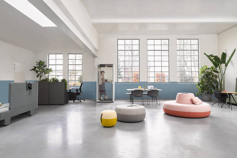 Loungescape Powernap, Sliding Door Cabinet, Balance, Ease, Qabin Call, Pyramid, Well Armchair, Recharge 45, Recharge 100, Recharge 165, Revolt, Engage Ahrend Loungescape Powernap and SDK Balance with Ease and Qabin with Recharge Pyramid and Well armchairs with female model in a Hybrid working community setting