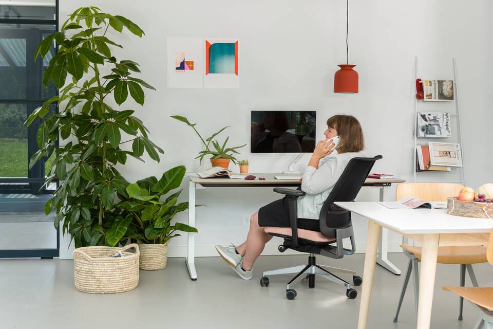 Balance, Ease Royal Ahrend balance workstation in white with oak tabletop with Ease office chair upholstered in pink and black with female model interior view