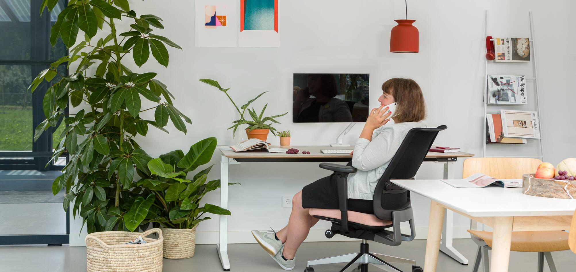 Balance, Ease Royal Ahrend balance workstation in white with oak tabletop with Ease office chair upholstered in pink and black with female model interior view