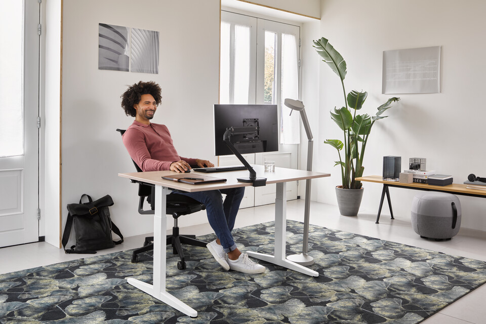 Home, Ease, Pyramid Bench 12, Recharge 45 Ahrend Home HVM desk in white with oak tabletop and black Ease office chair with grey Recharge and Pyramid bench with male model in a work from home setting