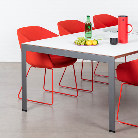 Delta, Hesta Royal Ahrend Delta table in grey with grey tabletop with red Hesta chairs front left view