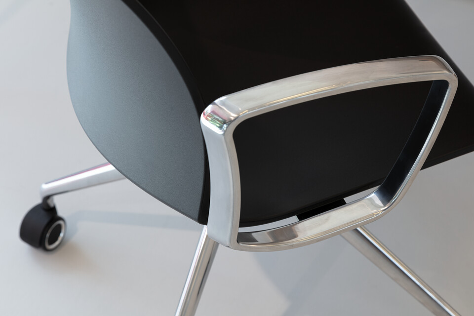 WELL Royal Ahrend Well trestle base chair on castors with polished chrome frame and armrests with anthracite shell top left detail view
