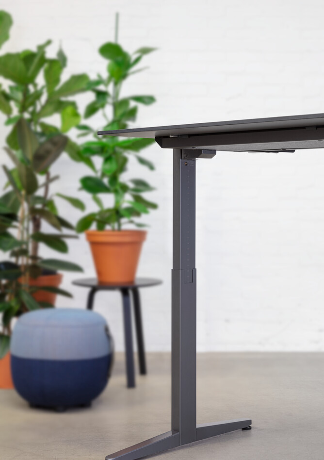 Balance Lift, Recharge 45 Royal Ahrend Balance Lift workstation in grey with charcoal top in stand position and blue Recharge 25 stool front right detail view